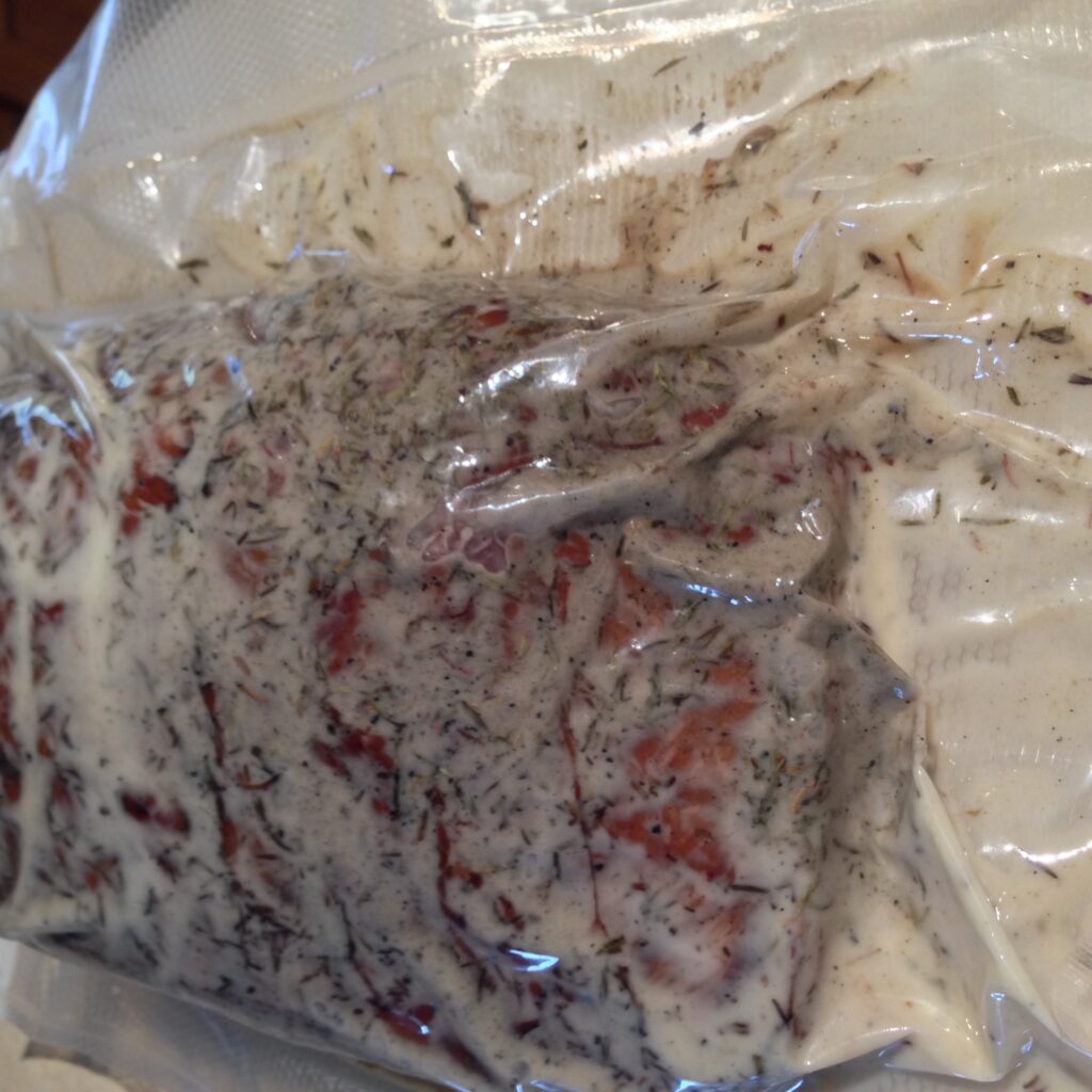 Hardwood-Smoked beef vacuum sealed with fresh herbs for sous vide cooking.